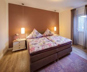 una camera con letto, comodino e letto sidx sidx sidx. di Landhaus Bad Bertrich a Bad Bertrich