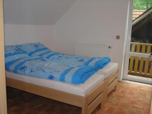 Una cama con sábanas azules en un dormitorio en Penzion U Tomášů en Všechovice