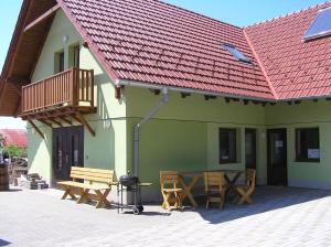 eine Terrasse mit 2 Bänken, einem Tisch und einem Balkon in der Unterkunft Penzion U Tomášů in Wschechowitz