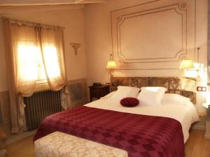 a bedroom with a bed with a checkered blanket at Hotel Plaza in Castejón de Sos