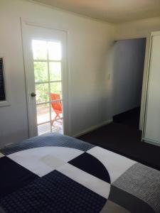 a bedroom with a bed with a black and white quilt at Cottage on Cork Steadman Cottage in Winton