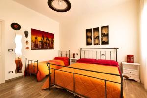 a bedroom with two beds and a clock on the wall at B&B Casa Rossella in Bari