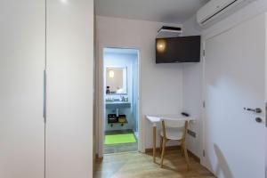 een witte kamer met een tafel en een televisie aan de muur bij City Garden Bed and Breakfast in Valencia