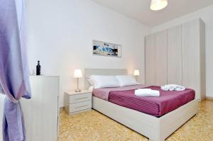 ローマにあるComfort Suite Mariniana close to the Vaticanの白いベッドルーム(紫の毛布付きのベッド付)