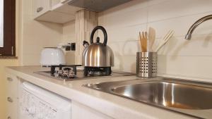 a kitchen with a sink and a tea kettle at Loft al Vicoletto sul Mare in Letojanni