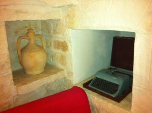 a room with a stone wall with a vase and a keyboard at Il Trulletto in Impalata