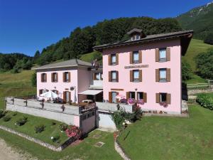 eine Luftansicht eines rosa Hauses auf einem Hügel in der Unterkunft Albergo Alpino da Tullio in Avio