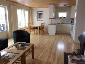 a living room and kitchen with a table and chairs at Siljan Utsikt Semesterhus in Sjurberg