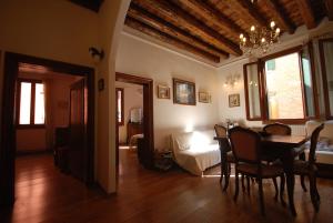 a living room with a dining room table and a bedroom at La Galea in Venice