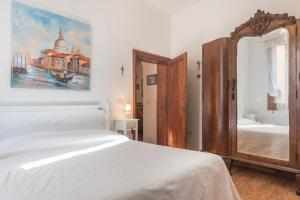 a bedroom with a white bed and a mirror at La Galea in Venice