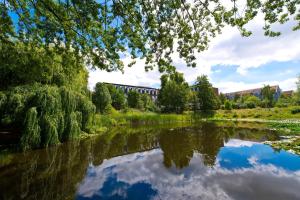 Una veduta di un fiume con un ponte sullo sfondo. di Living Hotel Weißensee a Berlino