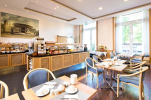 un ristorante con tavoli, sedie e un bancone di Living Hotel Weißensee a Berlino