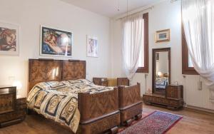een slaapkamer met een groot houten bed en een spiegel bij La Galea in Venetië