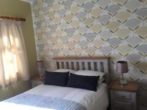 a bedroom with a bed with a patterned wall at Viewmount in Thomastown