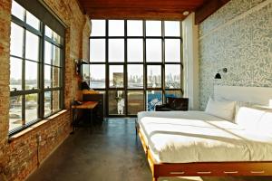 a bedroom with a bed and a large window at Wythe Hotel in Brooklyn