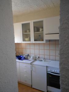 ランペドゥーザにあるCasa a Calacretaの白いキャビネット、シンク、食器洗い機付きのキッチンが備わります。