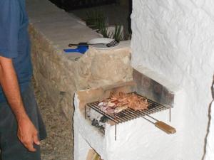 a man cooking food in a brick oven at Casa a Calacreta in Lampedusa