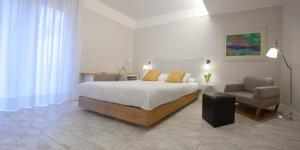 een slaapkamer met een bed en een stoel bij Best Season in Reggio di Calabria