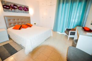 a bedroom with a bed with orange pillows on it at Algarpraia in Carvoeiro
