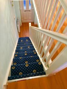 a staircase with a blue and yellow patterned carpet at Angel's (station accommodation) in Cambridge