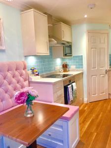 a kitchen with a vase of flowers on a table at Angel's (station accommodation) in Cambridge