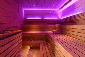 - un sauna avec des lumières violettes dans une pièce dans l'établissement Hotel Rössl, à Rablà
