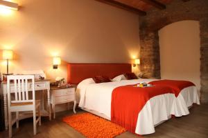a bedroom with a bed and a desk and a bed at Hotel Rural Can Vila in Sant Esteve de Palautordera
