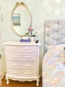 a bedroom with a white dresser and a mirror at Angel's (station accommodation) in Cambridge