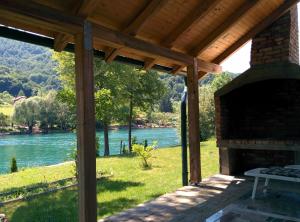 eine Terrasse mit einem Kamin und Flussblick in der Unterkunft Holiday Home Dvoslap in Bihać