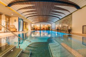 une grande piscine avec un grand plafond dans l'établissement Adler Suite & Stube, à Villabassa