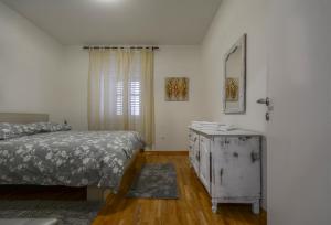 a bedroom with a bed and a dresser and a window at Apartment Vicenco top location in Split