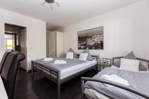 een slaapkamer met 2 bedden en een tafel. bij Hotel Rühen, 24 Stunden Check in, kostenfreie Parkplätze in Rühen