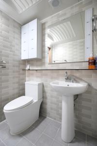 a white bathroom with a toilet and a sink at SB House in Suwon