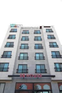 a tall white building with a sign on it at SB House in Suwon