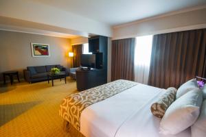 a hotel room with a large bed and a living room at Crowne Plaza Managua, an IHG Hotel in Managua