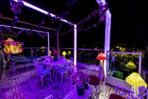 a patio with purple lighting and tables and chairs at Once21 Apartment in Guadalajara