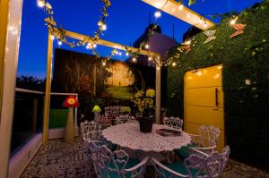 a patio with a table and chairs and lights at Once21 Apartment in Guadalajara