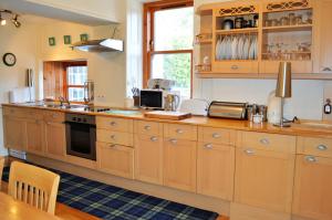 a kitchen with wooden cabinets and a counter top at Aldersyde in Tighnabruaich