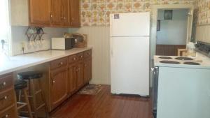 a kitchen with a white refrigerator and wooden cabinets at Aunt Jane's Yellow House in Put-in-Bay