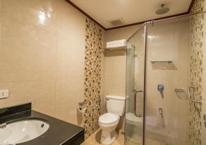 a bathroom with a sink and a toilet and a shower at Coral Cliff Hotel in El Nido
