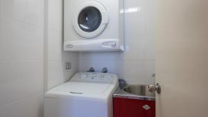 a small kitchen with a sink and a washing machine at Alexander Holiday Apartments in Gold Coast