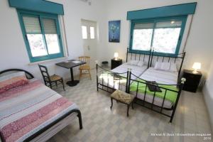 Auberg-Inn Guesthouse في أريحا: غرفة نوم بسرير وطاولة وكراسي