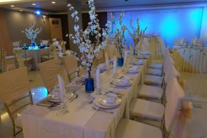 a long table with white tables and chairs with flowers at Hotel Estrella in Tacloban