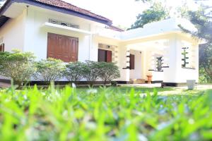una casa blanca con césped delante en Cinnamon Estate Villa, en Matara