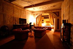 Hotel Locanda Di Bagnara في Bagnara di Romagna: غرفة معيشة بها أريكة وكراسي وتلفزيون