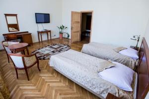 a room with two beds and a table and a television at Pałac w Kobylnikach in Kruszwica +13 photos
