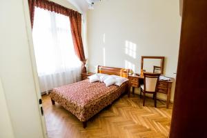 een slaapkamer met een bed, een bureau en een raam bij Pałac w Kobylnikach in Kruszwica