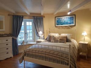 a bedroom with a large bed and a window at La Coulombe Manoir De Hérouville in Litteau