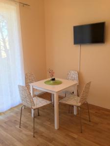 a white table with chairs and a television on a wall at Fortuuna 5 Apartment in Tartu