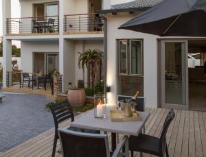 - une table en bois avec une bougie sur la terrasse dans l'établissement Ocean Bay Guesthouse, à Port Elizabeth